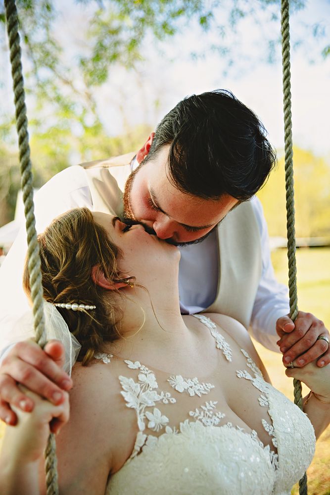 Couple sharing a kiss on a rope swing