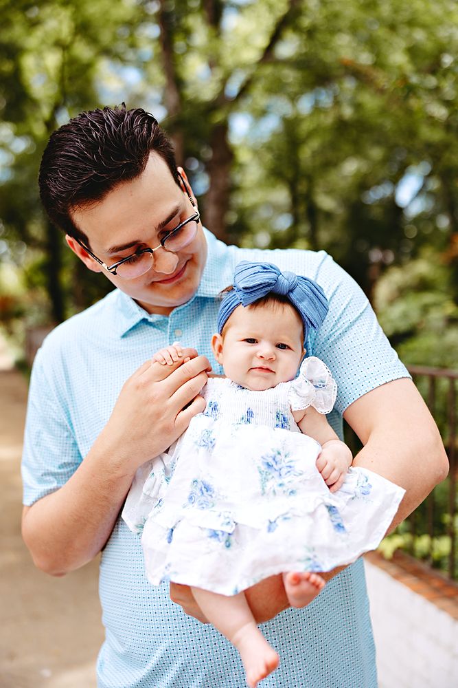Dad holding his baby daughter outdoors