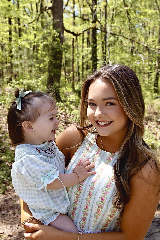 Mom laughing with her toddler in the spring woods